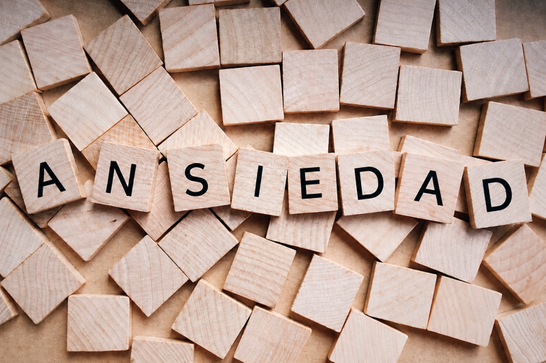 La palabra ansiedad formada con letras de madera sobre una mesa