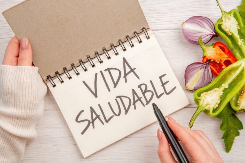 Cuaderno con las palabras Vida Saludable junto a vegetales frescos